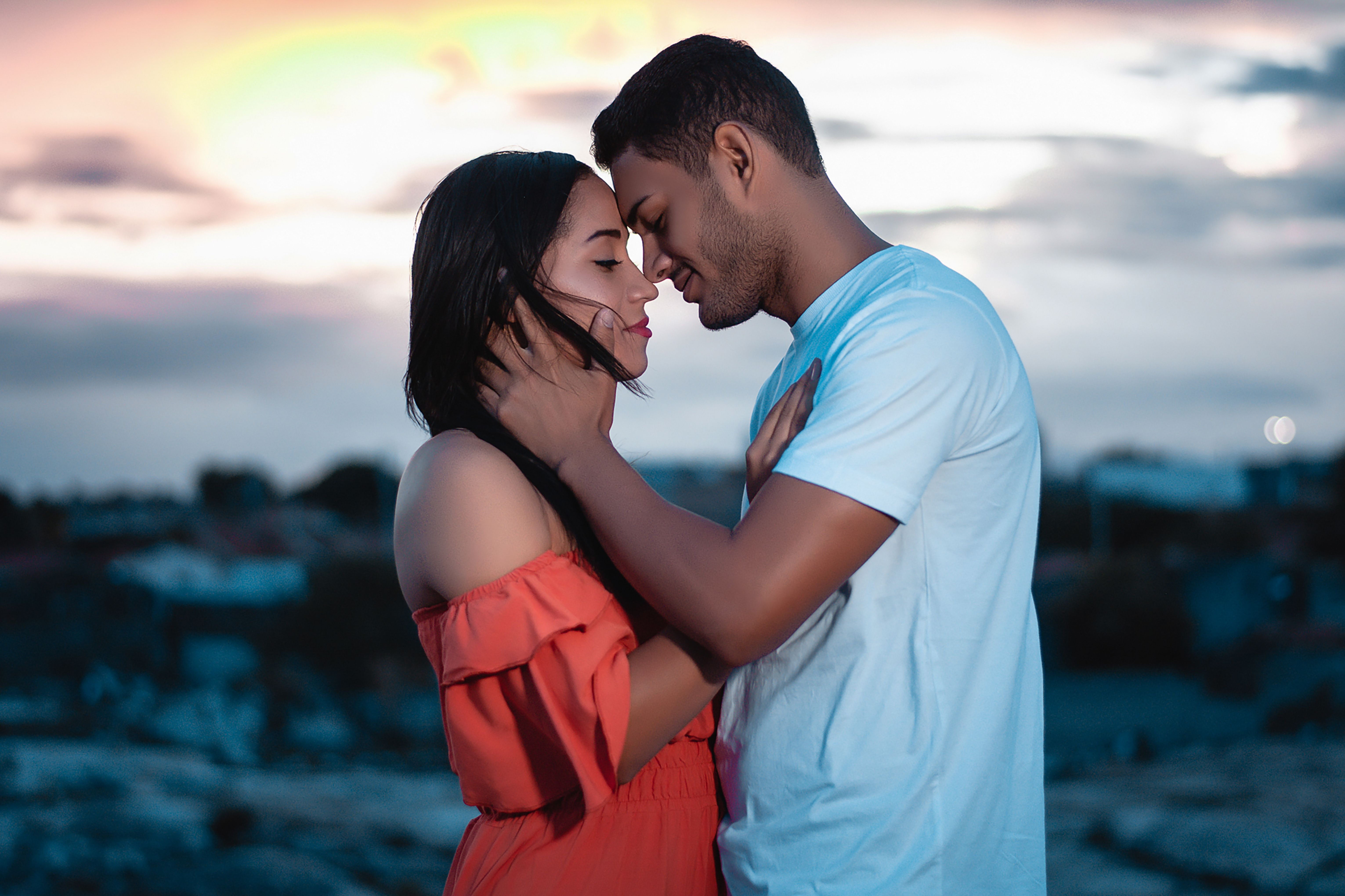 A loving couple embraces during a beautiful sunset outdoors, symbolizing genuine romance and togetherness