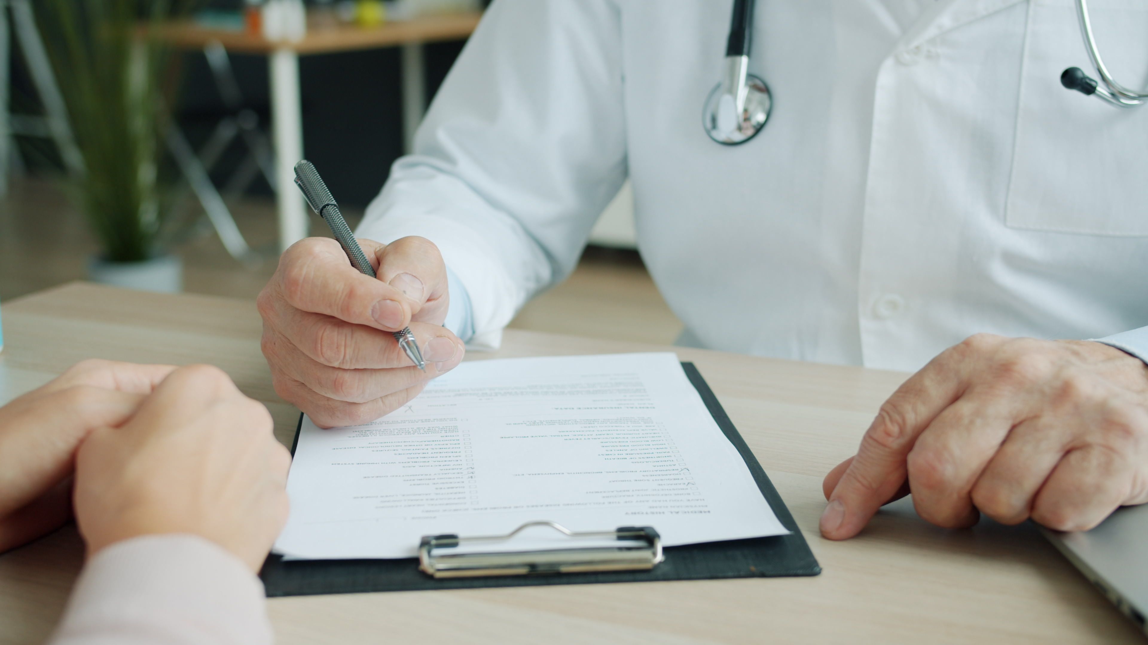 Close-up of doctor and patient reviewing medical documents during a consultation