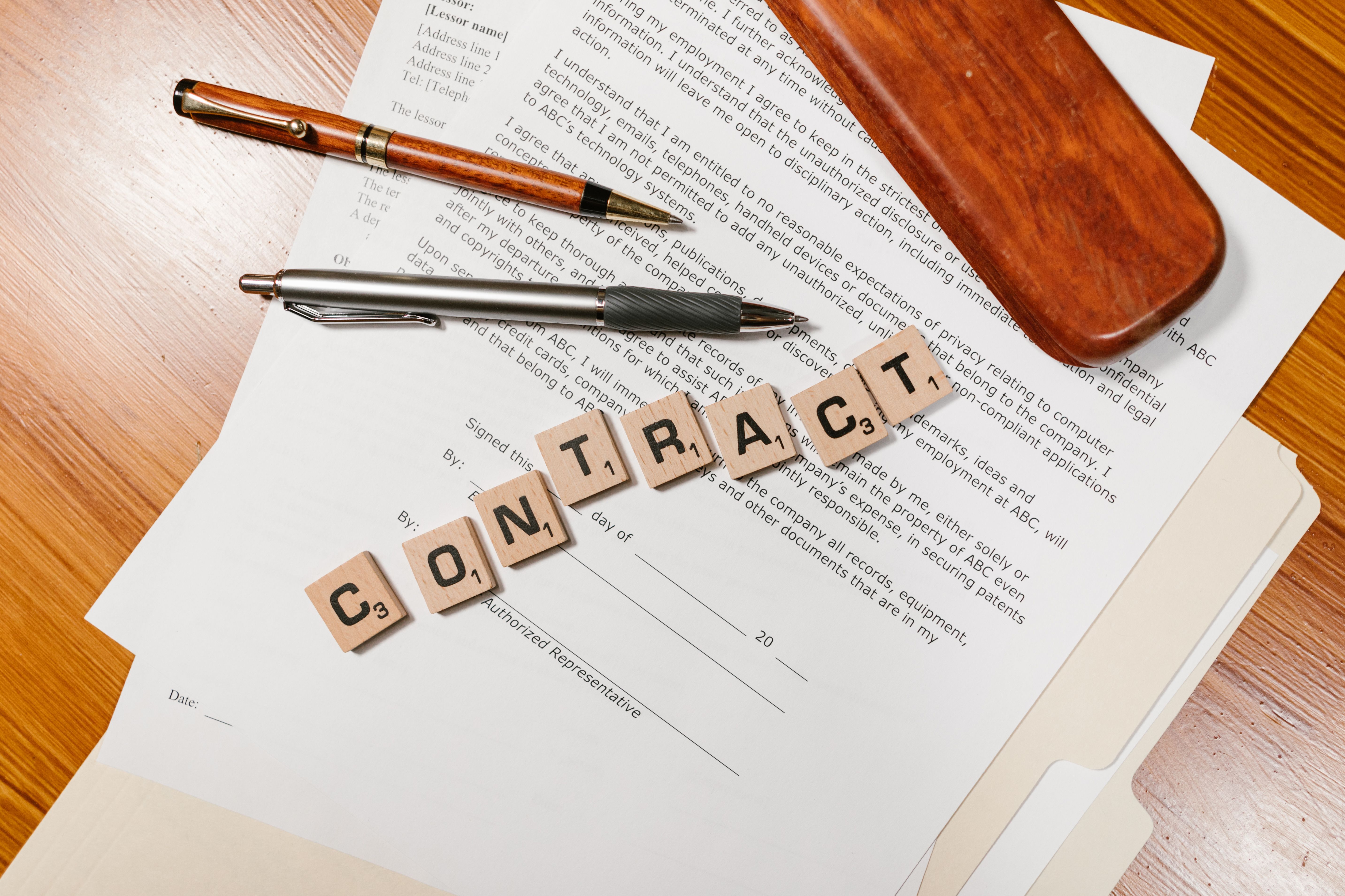 Close-up of contract papers with tiles spelling CONTRACT, symbolizing litigation finance agreements